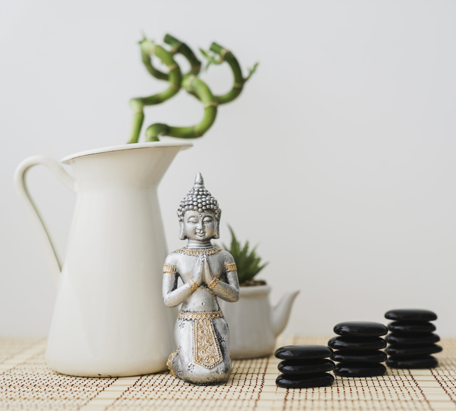 figure-bouddha-devant-plante-bambou-pierres-volcaniques